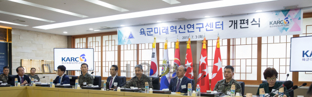 김용우 육군참모총장(가운데 태극기 앞)이 3일 계룡대에서 열린 육군미래혁신연구센터 개편식에서 자문위원, 연구원들과 함께 육군의 나아갈 길을 논의하고 있다.