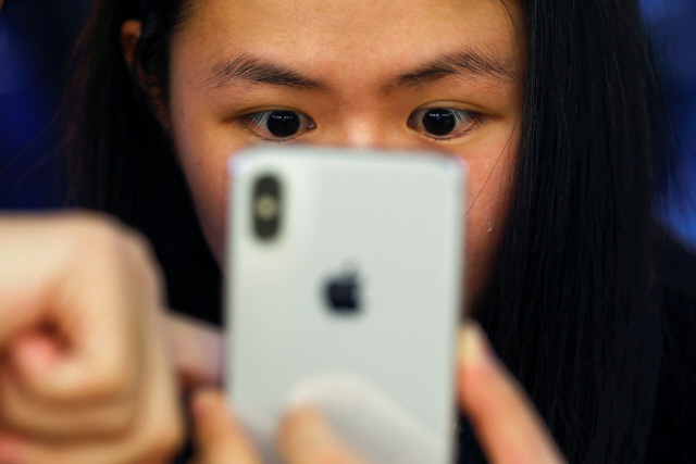한 중국 소비자가 지난해 11월 3일 애플 스토어에서 공개된 ‘아이폰X’를 살펴보고 있다. /베이팅=로이터연합뉴스