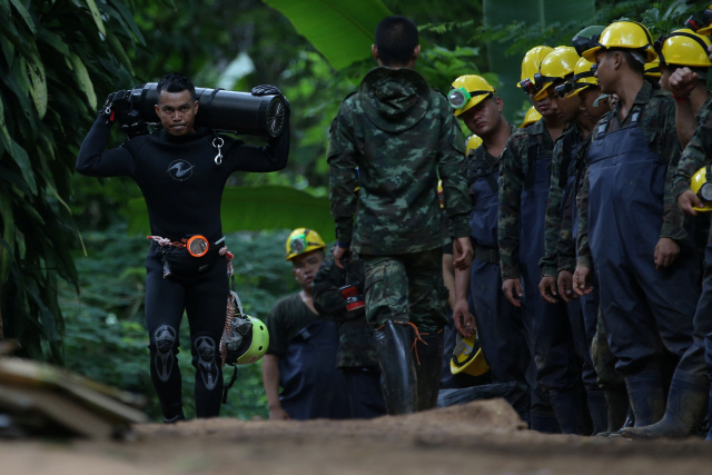한 구조대원이 6일(현지시간) 태국 치앙라이 인근 동굴에 갇힌 소년들과 코치를 구조하기 위해 산소통을 옮기고 있다. /치앙라이=로이터연합뉴스
