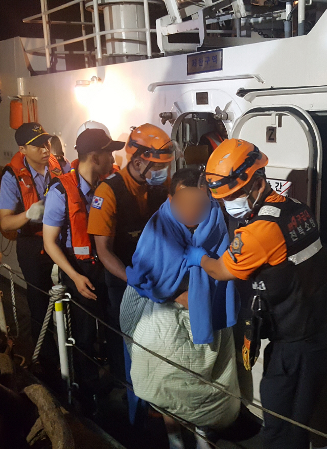 8일 오후 해경과 소방대원이 전북 군산시 어청도 인근 해상에서 뒤집힌 어선에서 구조한 생존자를 병원으로 옮기고 있다./연합뉴스