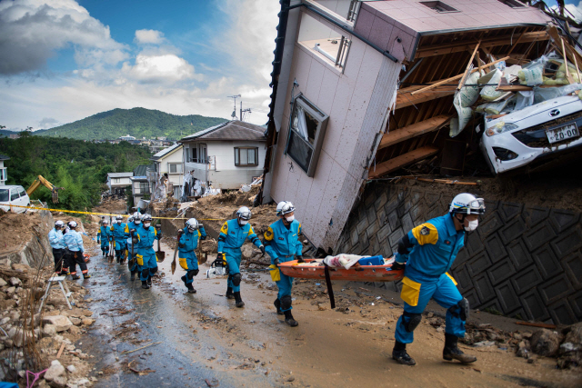 일본 폭우 사태의 대표 지역으로 꼽히는 히로시마현 쿠마노에서 9일 경찰들이 구조장비를 운반하고 있다.     /쿠마노=AFP연합뉴스