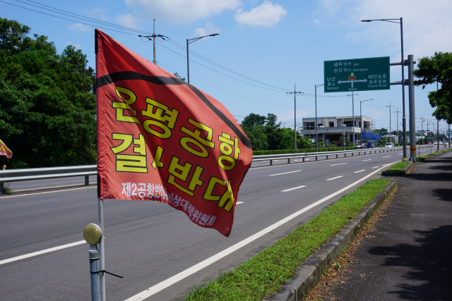 제주2공항 예정부지로 지정된 성산읍 온평리 일대 도로에 ‘온평공항 결사반대’라는 빨간색 깃발이 나부끼고 있다. /사진=김선덕기자