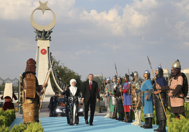 레제프 타이이프 에르도안(오른쪽) 터키 대통령과 부인 에미네 여사가 9일(현지시간) 터키 수도 앙카라의 대통령궁에서 열린 취임식에서 전통 군복과 무기를 갖춘 근위병들을 사열하고 있다.     /앙카라=AP연합뉴스