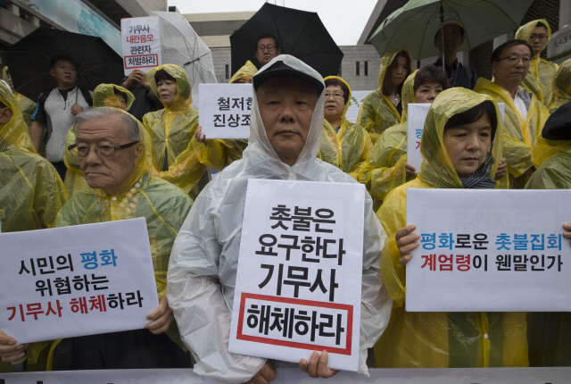 9일 오후 서울 세종문화회관 앞에서 열린 ‘기무사 내란음모 사건에 대한 시민사회 긴급기자회견’에서 참석자들이 기무사 해체 등을 촉구하는 내용의 피켓을 들고 있다./연합뉴스