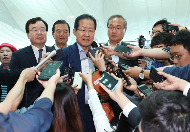 홍준표 자유한국당 전 대표가 휴식을 위해 11일 인천국제공항을 통해 미국으로 출국하며 취재진의 질문에 답하고 있는 모습./연합뉴스