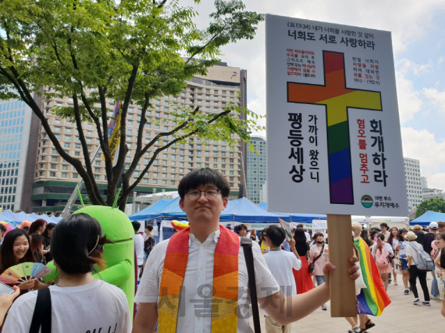 14일 서울퀴어문화축제 참가자가 “성소수자 혐오를 멈추고 회개하라”는 팻말을 들고 있다./오지현기자