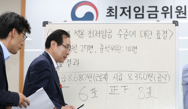 14일 오전 정부세종청사 고용노동부에서 열린 최저임금위원회 전원회의에서 내년도 최저임금이 확정돼 류장수 위원장(오른쪽)과 김성호 부위원장이 브리핑을 마친 뒤 회의장을 나서고 있다. /연합뉴스