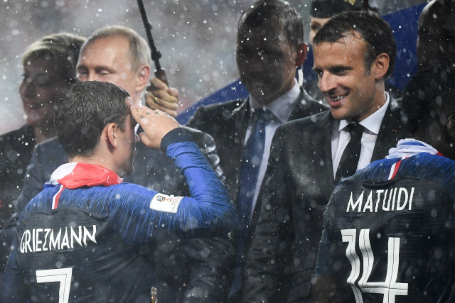 프랑스 대표팀의 앙투안 그리에즈만(왼쪽)이 16일 러시아월드컵 우승 뒤 시상식에서 에마뉘엘 마크롱 프랑스 대통령에게 거수경례를 하고 있다. /모스크바=AFP연합뉴스
