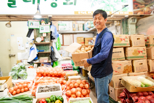 서울시의 ‘서울상인’ 1호로 선정된 김창선씨가 자신이 운영하는 ‘달래상회’ 앞에서 감자상자를 옮기다 웃음을 짓고 있다. /사진제공=서울시