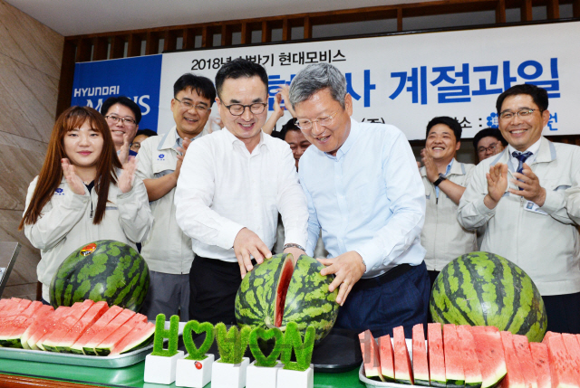 김대곤(앞줄 왼쪽) 현대모비스 구매지원담당 상무가 초복인 지난 17일 광주 소재 협력업체인 ㈜호원을 찾아 이 회사의 양진석 대표와 함께 수박을 자르고 있다. 현대모비스는 이달 말까지 전국 우수협력사 250곳과 1,300여 대리점에 감사장과 함께 수박 1만통을 전달할 예정이라고 18일 밝혔다. /사진제공=현대모비스