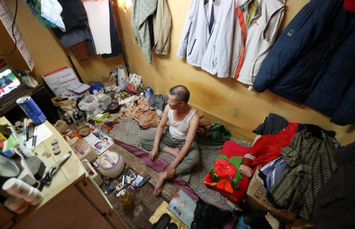 35도를 넘는 찜통더위가 지속되고 있는 지난 18일 오후 부산 동구의 한 쪽방에서 양호철 씨가 더위와 사투를 벌이고 있다. /연합뉴스