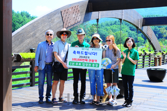 김용하(사진 왼쪽에서 세번째) 국립백두대간수목원장이 올해 10만번째 방문객이 된 황혜정(〃네번째)씨에게 1년 무료입장권을 수여하고 기념촬영을 하고 있다. 사진제공=국립백두대간수목원