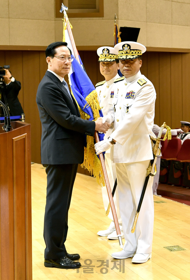 19일 계룡대 대강당에서 열린 제32대·33대 해군참모총장 이·취임식에서 심승섭 신임 해군참모총장(맨 오른쪽)이 송영무 국방장관으로부터 해군기를 이양 받고 있다.