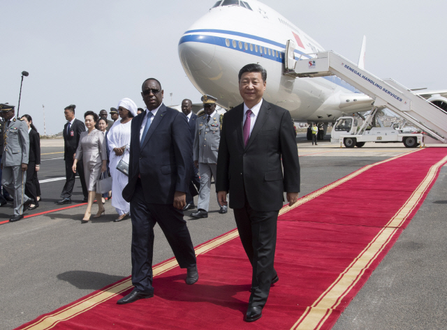 시진핑(오른쪽) 중국 국가주석이 21일(현지시간) 첫 아프리카 순방국인 세네갈의 다카르 국제공항에서 마키 살 세네갈 대통령의 환대를 받으며 함께 이동하고 있다. 시 주석이 집권 2기 첫 순방 대륙으로 아프리카를 선택한 것은 자원외교·일대일로(육상·해상 실크로드) 프로젝트에 박차를 가하겠다는 의지로 분석된다.      /다카르=신화연합뉴스