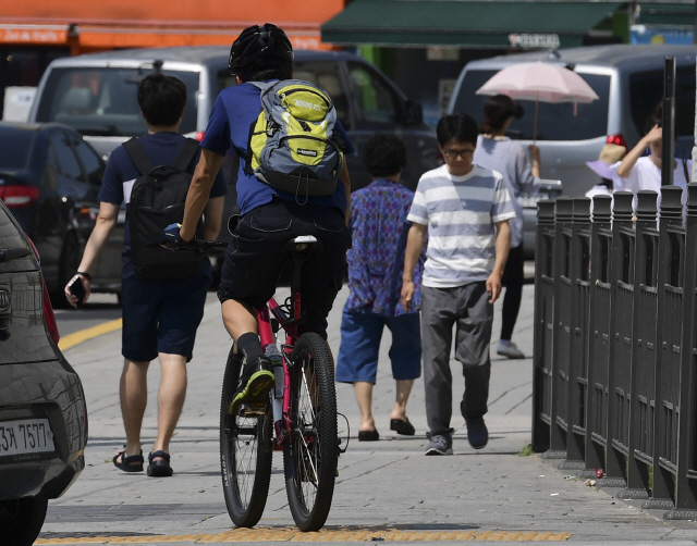 22일 오전 서울 종로 거리 인도에서 한 자전거가 사람들 사이로 주행하고 있다./송은석기자