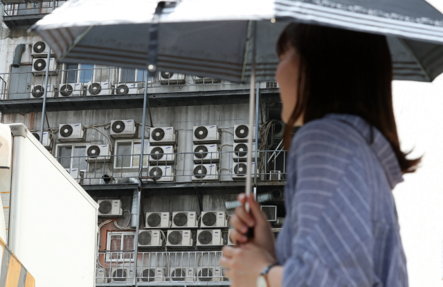 전국 대부분의 지역에 폭염특보가 발효된 지난 15일 서울 남대문로에서 시민들이 양산으로 햋볕을 가린 채 길을 걷고 있다./서울경제