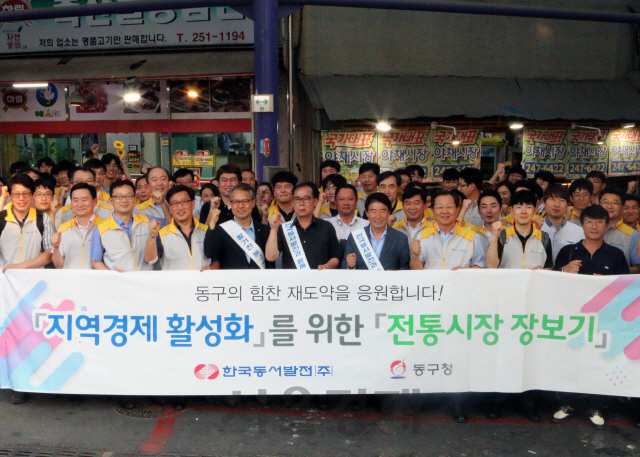 한국동서발전 임직원들이 지난 19일 조선산업 위기로 침체된 울산 동구 지역의 지역경제 활성화를 위해 남목시장을 방문해 전통시장 장보기 행사를 한 후 기념촬영을 하고 있다. /사진제공=한국동서발전