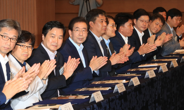 25일 오전 서울 중구 대한상공회의소에서 열린 ‘소상공인 수수료 부담 제로 결제서비스’ 도입을 위한 업무협약식에서 홍종학 중소벤처기업부 장관(왼쪽 세번째), 박원순 서울시장(왼쪽 네번째)등의 참석자들이 박수를 치고 있다./연합뉴스