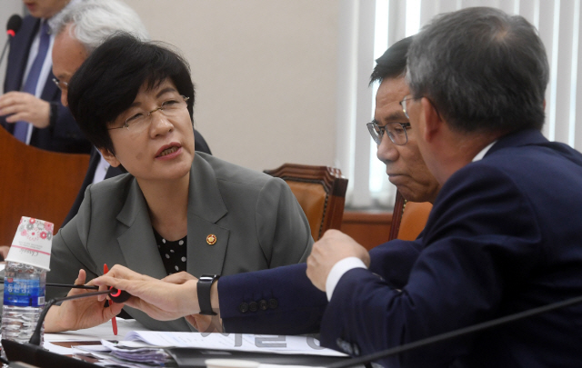 김영주(왼쪽) 고용노동부 장관이 25일 서울 여의도 국회에서 열린 환경노동위원회 전체회의에서 관계자들과 대화하고 있다./권욱기자