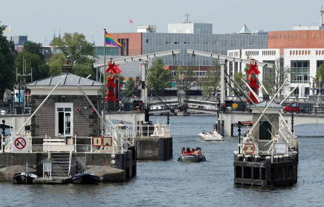 24일(현지시간) 관광객들이 탄 보트 한 대가 네덜란드 암스테르담의 강을 지나고 있다. /로이터연합뉴스