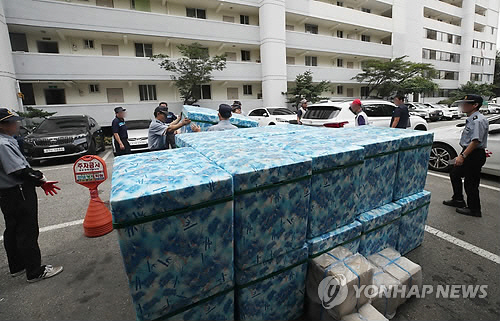 5일 오전 서울 노원구 하계동 장미아파트에 전력 사용 증가에 따른 변압기 과부하 탓으로 전기공급이 끊겨 경비원들이 각 가정에 전달할 아이스박스를 나르고 있다. (사진=연합뉴스)