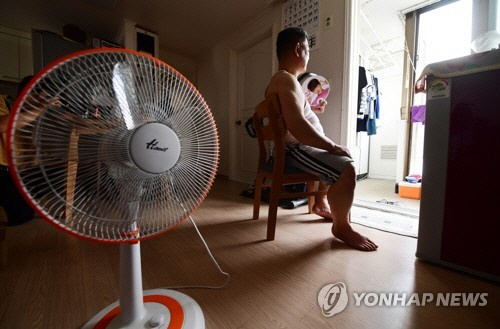 5일 서울 노원구 하계동 장미아파트에 전력 사용 증가에 따른 변압기 과부하 탓으로 전기공급이 끊겨 한 주민이 작동하지 않는 선풍기 옆에서 부채로 더위를 식히고 있다. (사진=연합뉴스)