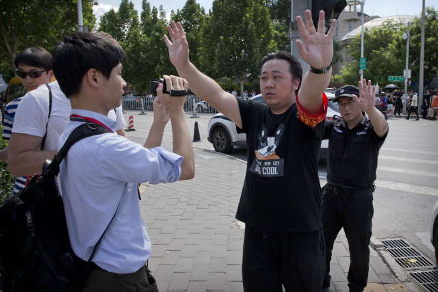 26일 중국 베이징 주재 미국대사관 인근에서 폭발로 보이는 사고가 발생하자 공안들이 기자들을 막아서며 현장을 통제하고 있다.   /베이징=AP연합뉴스
