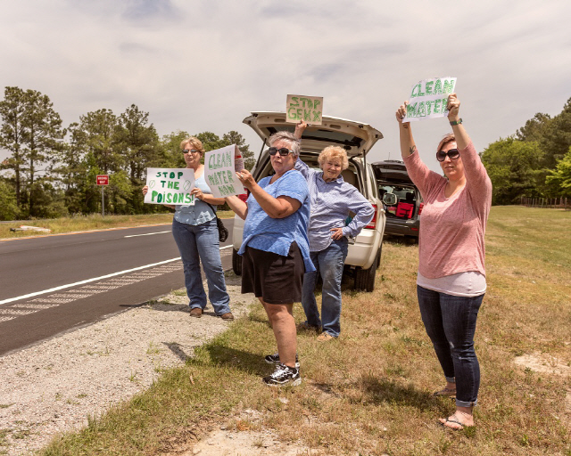 케무어스 공장 입구 외곽, 노스캐롤라이나 주 87번 국도 도로변에서 주민들이 시위를 벌이고 있다.