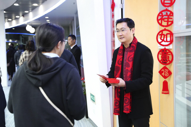 텐센트 CEO 마화텅이 직원들에게 현금을 담은 ‘붉은 봉투’를 나눠주고 있다.