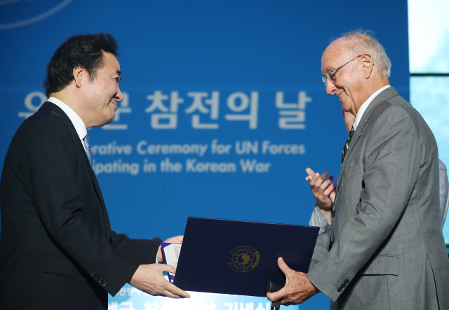 이낙연 국무총리가 27일 서울 동대문디자인플라자에서 열린 6·25전쟁 유엔군 참전의 날 기념식에 참석해 영국 한국전 참전용사 협회 켄트지부 회장 브라이언 패릿 씨에게 훈장을 주고 있다./연합뉴스