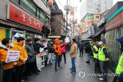 맘상모(맘편히장사하고픈상인모임) 회원들이 지난 1월 서울 종로구 서촌의 ‘본가궁중족발’ 앞에서 법원 집행관이 강제집행 하지 못하도록 가게 앞을 막고 있다./연합뉴스