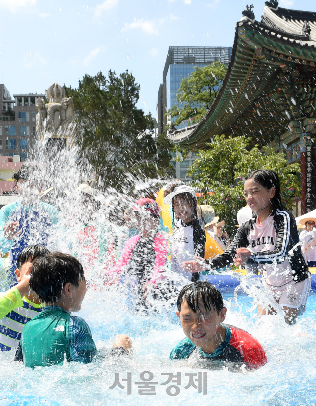 폭염이 계속되는 29일 서울 종로구 견지동 조계사 경내에 마련된 물놀이장에서 여름방학을 맞아 여름불교학교에 참가한 어린이들이 물놀이를 하며 더위를 이겨내고 있다./권욱기자