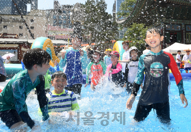 폭염이 계속되는 29일 서울 종로구 견지동 조계사 경내에 마련된 물놀이장에서 여름방학을 맞아 여름불교학교에 참가한 어린이들이 물놀이를 하며 더위를 이겨내고 있다./권욱기자