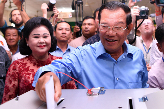 Cambodia‘s Prime Minister Hun Sen (R) casts his vote during the general elections as his wife Bun Rany (L) looks on in Phnom Penh on July 29, 2018.   Cambodia went to the polls early on July 29 in an election to be easily won by strongman premier Hun Sen after the only credible opposition was dissolved last year, effectively turning the country into a one-party state.   / AFP PHOTO / Manan VATSYAYANA      <저작권자(c) 연합뉴스, 무단 전재-재배포 금지>