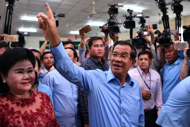 훈 센(가운데) 캄보디아 총리가 29일(현지시간) 투표장에서 지지자들에게 인사하고 있다. /프놈펜=AFP연합뉴스