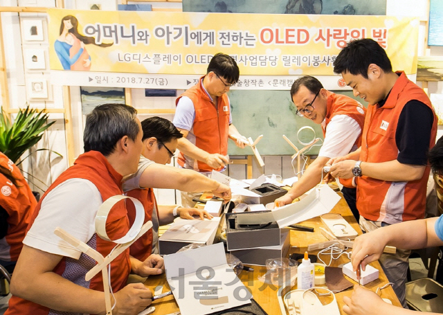 박성수(오른쪽 두번째) LG디스플레이 OLED조명사업담당 상무를 비롯한 임직원들이 미혼모를 위한 OLED수유등을 직접 제작하고있다. 임직원들의 재능기부로 만든 수유등과 선물세트는 지난 30일, 미혼모 30명에게 전달됐다./사진제공=LG디스플레이