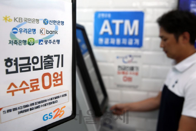 GS25 점포 내 설치된 현금자동입출금기(ATM)에서 한 고객이  현금을 인출하고 있다. /사진제공=GS리테일