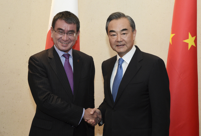 고노 다로(왼쪽) 일본 외무상과 왕이 중국 외교부장이 2일 싱가포르에서 만나 악수하고 있다. /싱가포르=AP연합뉴스
