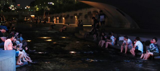 폭염과 열대야가 계속된 7월31일 오후 서울 청계천을 찾은 시민들이 물에 발을 담그고 더위를 식히고 있다./연합뉴스