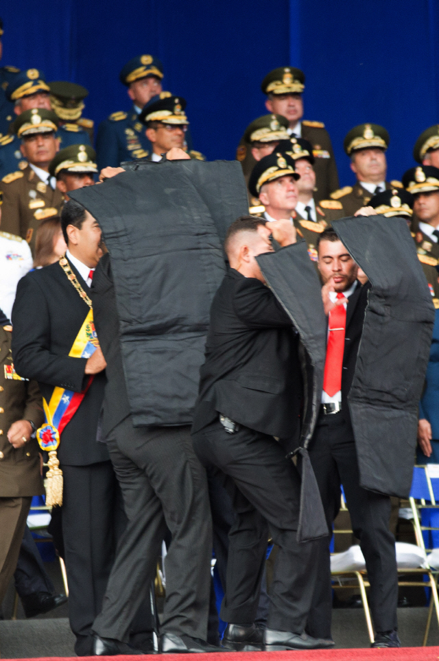 4일(현지시간) 베네수엘라 수도 카라카스에서 열린 군 행사 도 중 굉음이 나자 경호원들이 니콜라스 마두로 베네수엘라 대통령을(왼쪽 첫번째) 감싸고 있다./카라카스=신화통신연합뉴스