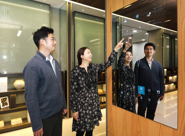 삼성물산 직원들이 ‘래미안 IoT홈랩’기술을 적용한 스마트 거울을 통해 에너지 사용량을 살펴보고 있다./사진제공=삼성물산