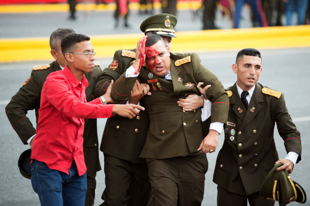 4일(현지시간) 베네수엘라 수도 카라카스에서 열린 방위군 창설 81주년 기념식에서 니콜라스 마두로 대통령의 연설 도중 드론을 이용한 폭발물 공격이 발생한 직후 한 군인이 피를 흘리며 대피하고 있다./연합뉴스
