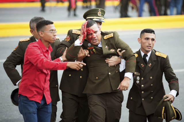 4일(현지시간) 베네수엘라 수도 카라카스에서 열린 방위군 창설 81주년 기념식에서 니콜라스 마두로 대통령의 연설 도중 드론을 이용한 폭발물 공격이 발생한 직후 한 군인이 피를 흘리며 대피하고 있다. /카라카스=AP신화연합뉴스