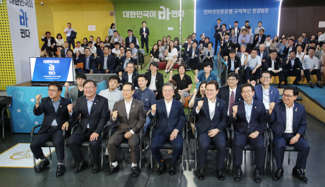 문재인 대통령이 7일 오후 서울시 중구 서울시청 시민청에서 열린 인터넷 전문은행 규제혁신 현장방문 행사에서 최종구 금융위원장, 더불어민주당 홍영표 원내대표 등 참석자들과 파이팅을 외치고 있다./연합뉴스