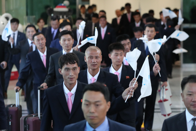 10일 오전 경기도 파주시 경의선 남북출입사무소에서 남북노동자통일축구대회에 참가하는 북측 선수단이 한반도기를 흔들며 버스로 이동하고 있다. /연합뉴스