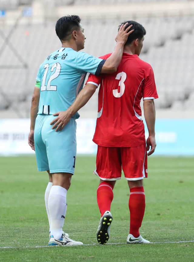 11일 오후 서울월드컵경기장에서 열린 남북노동자통일 축구대회 한국노총 대표팀과 북측 조선직업총동맹 건설노동자팀의 경기. 한국노총 대표팀 제용삼(왼쪽) 선수가 북한 건설노동자팀 문성호 선수와 어깨동무를 하고 있다. /연합뉴스