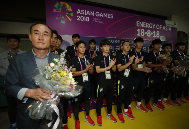 U-23 축구대표팀의 김학범(왼쪽) 감독과 선수들이 12일 오전 아시안게임 개최지인 인도네시아 자카르타의 수카르노 하타 국제공항에 도착해 기념촬영을 하고 있다. /자카르타=연합뉴스