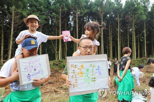 제주 ‘비자림로를 지키려는 시민 모임’에 아이를 데리고 나온 아빠들이 12일 오전 비자림로 확장공사 현장에서 공사 중단을 촉구하는 시위를 벌이고 있다. / 사진=연합뉴스