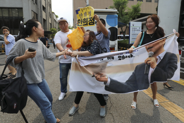 비서에 대한 성폭력 혐의로 기소된 안희정 전 충남지사가 1심에서 무죄를 선고받은 14일 오전 서울서부지법 앞에서 한 여성이 안 전 지사를 지지하는 사람의 현수막을 뺏으려 하고 있다./연합뉴스