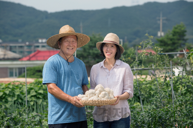 이현선 도움농장 대표와 이 대표의 부친이 경기도 용인에 위치한 농장에서 노루궁뎅이 버섯을 소개하고 있다. /사진제공=도움농장